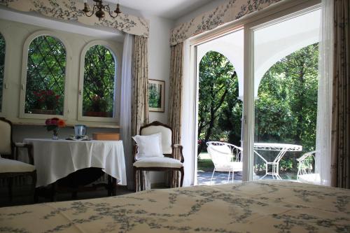 a bedroom with a bed and a table and chairs at Villa Olevano in Ascona