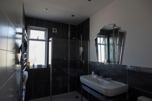 a bathroom with a sink and a mirror at The Estuary View in Thorpe Bay
