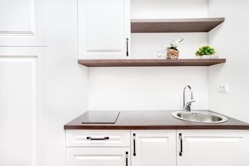 uma cozinha com armários brancos e uma pia em Magical View em Kotor
