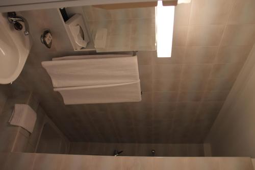 a bathroom with white towels hanging from the ceiling at Villa Olevano in Ascona