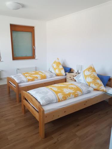 3 Betten in einem Zimmer mit Holzböden in der Unterkunft Ferienhaus Schiffer in Göttingen