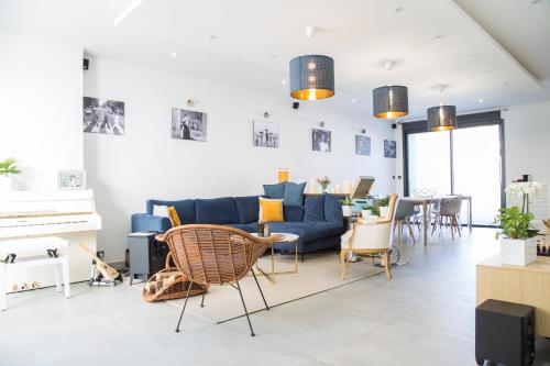 a living room with a blue couch and chairs at Spéciale Halloween - Idéal Familles & Groupes - 15min Parc Spirou - Nocturnes les 25, 30, 31 octobre et le 1er novembre - 10min Avignon - 5min Gare - Grand jardin clos - Parking gratuit - Au calme - Maison haut de gamme in Sorgues