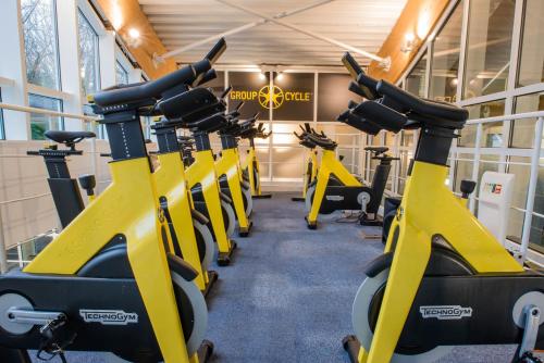 a row of exercise bikes in a gym at Manor Of Groves Hotel, Golf & Health Club in Sawbridgeworth