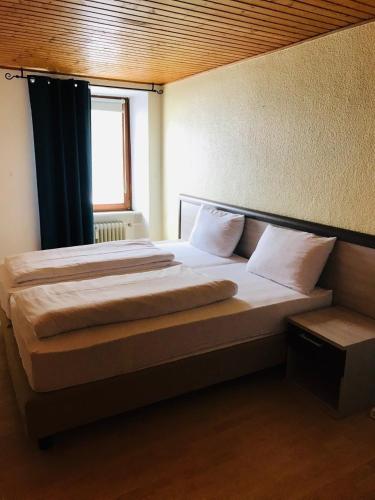 a large bed in a room with a window at Hotel-Restaurant Kastel in Bernkastel-Kues