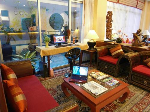 a living room with a couch and a table with a laptop at De Arni Bangkok - SHA Extra Plus in Bangkok