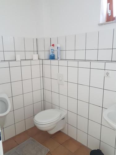 a white bathroom with a toilet and a sink at Ferienhaus Schiffer in Göttingen