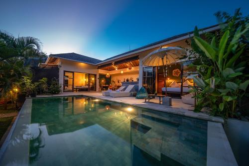 ジンバランにあるKarma House Ungasanの夜のプール付きヴィラ