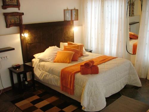 a bedroom with a large bed with an orange bow on it at Francor Guesthouse in Pretoria