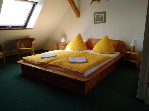 a bedroom with a bed with yellow sheets and a window at Pension und Gasthof Zur Scheune in Flecken Zechlin