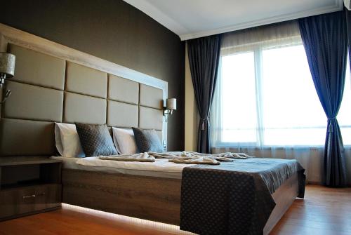 a bedroom with a large bed with a large window at Dune Boutique Pomorie in Pomorie
