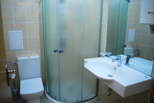a bathroom with a shower and a toilet and a sink at Dune Boutique Pomorie in Pomorie