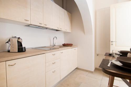 a kitchen with white cabinets and a sink at Dimora Via Vitti - Puglia Mia Apartments in Monopoli