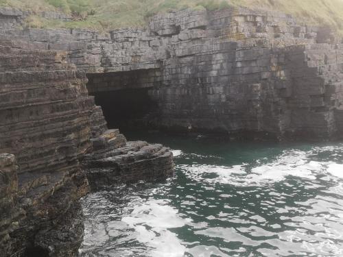 a cave in the side of a mountain with water at Ocean Heights B&B in Lissadell
