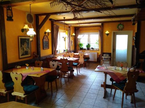 a restaurant with tables and chairs in a room at Pension und Gasthof Zur Scheune in Flecken Zechlin