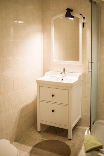 a white bathroom with a sink and a mirror at Province in Cēsis