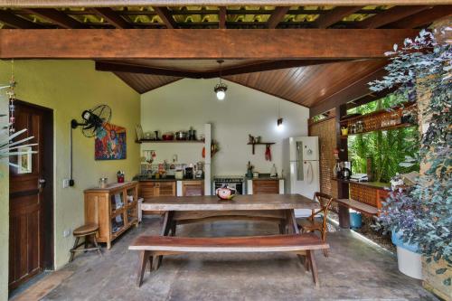 a kitchen with a wooden table and a refrigerator at Espaço CurAmar - Praia de Itamambuca in Ubatuba