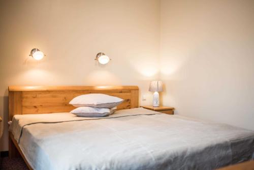 a bedroom with a bed with two pillows and two lights at Province in Cēsis