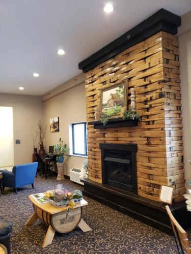 a living room with a large stone fireplace at Cobblestone Inn & Suites - Manning in Manning