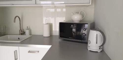 Una encimera de cocina con un microondas y un fregadero. en Klif w Mechelinkach, en Mechelinki