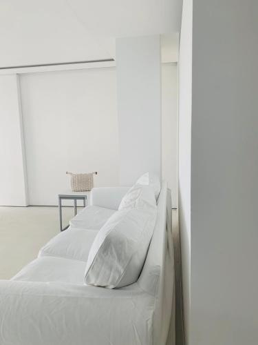 a white bed with white sheets and pillows at Acquabianca in Aci Castello