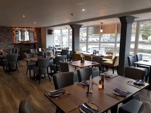 a dining room with tables and chairs and a restaurant at Islay Frigate Hotel in Tarbert