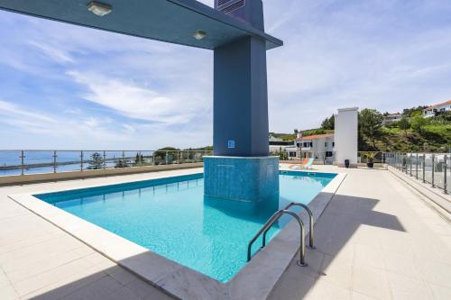 a swimming pool with a view of the ocean at Sesimbra Prime Apartment by be@home in Sesimbra