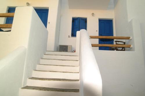 a set of stairs in a white building with blue doors at Votsalo Apartments in Naousa