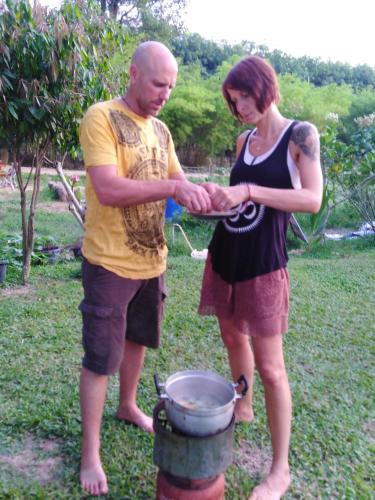 a man and a woman standing next to a barrel at Saengcha Farm Resort in Prachin Buri
