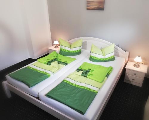 un letto con lenzuola e cuscini verdi di Villa Leanca a Binz