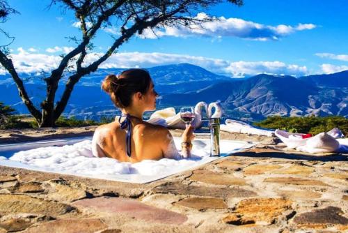 a woman sitting in a bubble bath in a hot tub at Tunas & Cabras Hotel in Ibarra