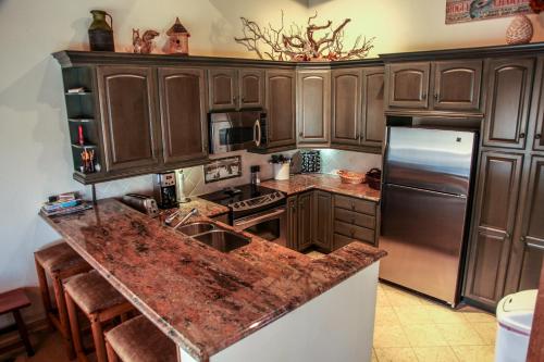 - une cuisine avec des placards en bois et un plan de travail en granit dans l'établissement Mammoth West #140 Condo, à Mammoth Lakes