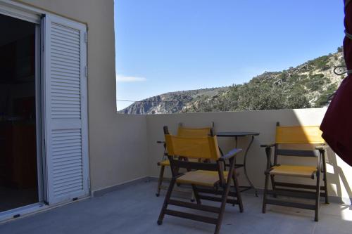 a group of chairs and a table on a balcony at Marinakis Sea View Studios in Sougia