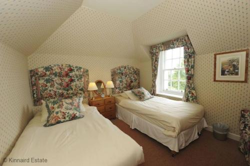a bedroom with two beds and a window at Castle Peroch in Dunkeld