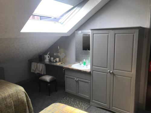 a bathroom with a sink and a skylight at Cornerways Guest House in Carlisle