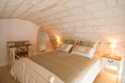 a bedroom with a large bed with a stone wall at Dimora Via Vitti - Puglia Mia Apartments in Monopoli