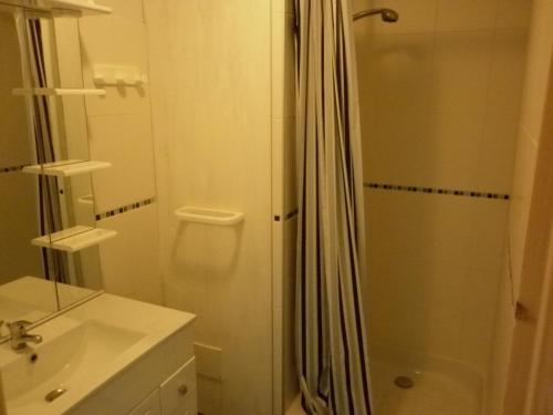 Un baño blanco con ducha y lavabo. en Camping La Verte Prairie, en Forest-Montiers