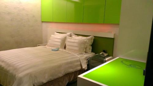 a small bedroom with a bed with green cabinets at Saual Keh Hotel in Taipei