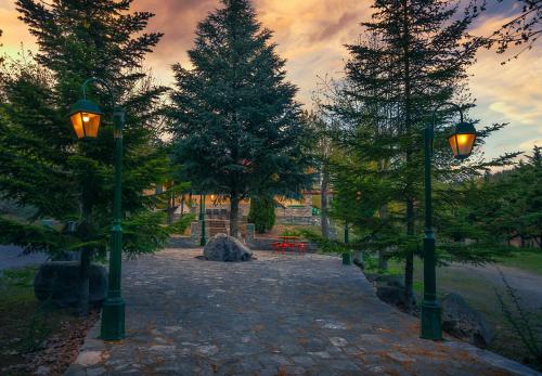a park with two street lights and two trees at River Side Rooms in Elassona