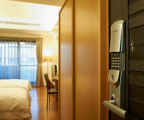 a hotel room with a bed and a phone at Master Hotel in Taipei