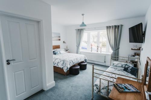 a bedroom with a bed and a window at Elysian Fields B&B in Helston