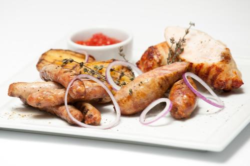 a white plate of food with sausages and potatoes at Biruza Club in Svyatopetrivske