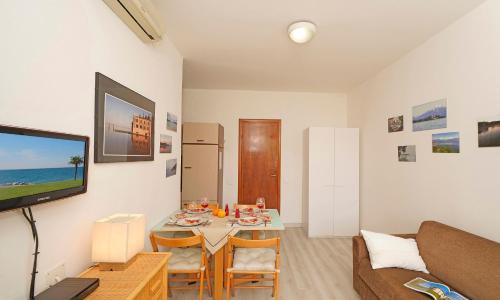 a living room with a table and a tv at Appartamento Romantica Pieve in Manerba del Garda