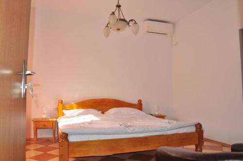 a bedroom with a wooden bed with a lamp at Casa Matei in Mahmudia