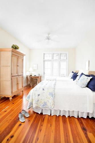 a bedroom with a large bed and a wooden floor at The Cottages on Charleston Harbor in Charleston