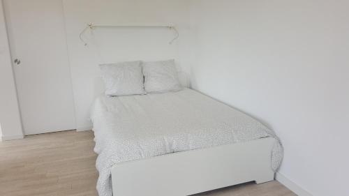 białe łóżko w białym pokoju z ramą w obiekcie Le Clos de Carinette w mieście Châteauneuf-du-Pape