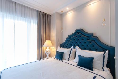 une chambre avec un grand lit et une tête de lit bleue dans l'établissement NLM Boutique Apartment, à Rome