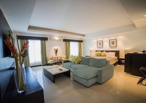 a living room with a couch and a bed at Hotel Grand Marlon in Chetumal