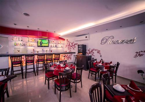 a restaurant with tables and chairs and a bar at Hotel Grand Marlon in Chetumal