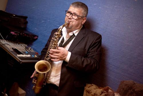 a man in a suit playing a saxophone at Biruza Club in Svyatopetrivske