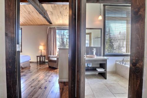 a bathroom with a sink and a tub in a room at Les Condos Du Lac Taureau- Rooms & Condos in Saint-Michel-des-Saints
